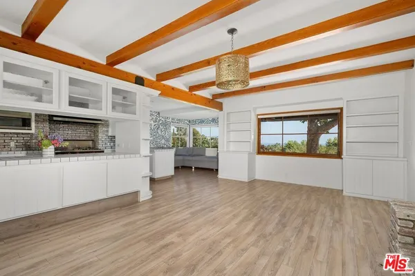 a open kitchen with white cabinets and wooden floor