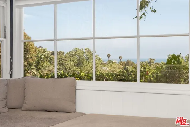 a view of a floor to ceiling window and tree