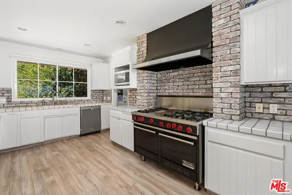 a kitchen with a stove a sink and a microwave