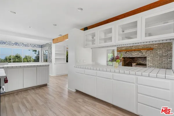 a kitchen with stainless steel appliances white cabinets and wooden floor