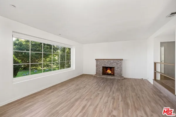a view of an empty room window and wooden floor