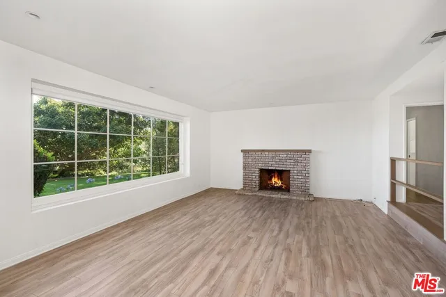 a view of an empty room window and wooden floor