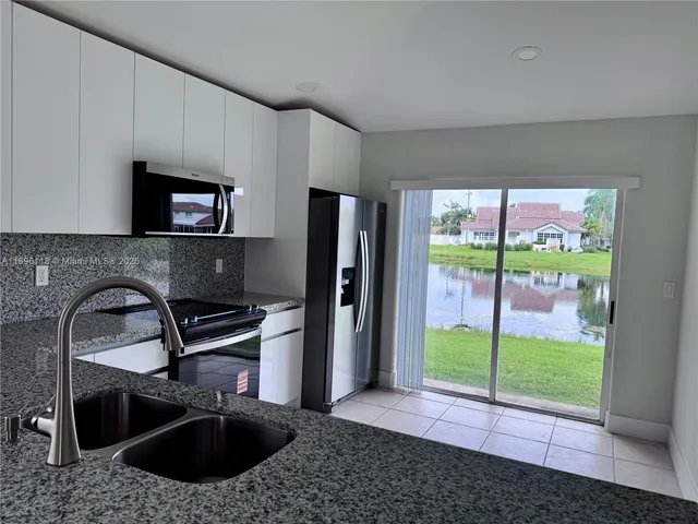 a kitchen with a sink a counter top space and stainless steel appliances