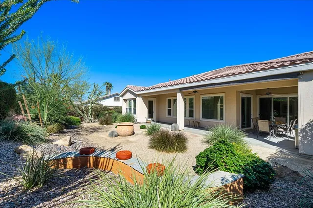 a view of a house with backyard and sitting area
