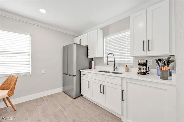 a kitchen with stainless steel appliances a sink cabinets and a window
