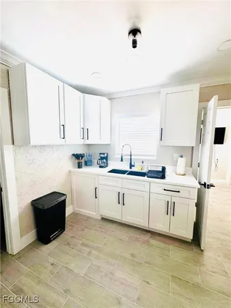 a kitchen with white cabinets and white appliances