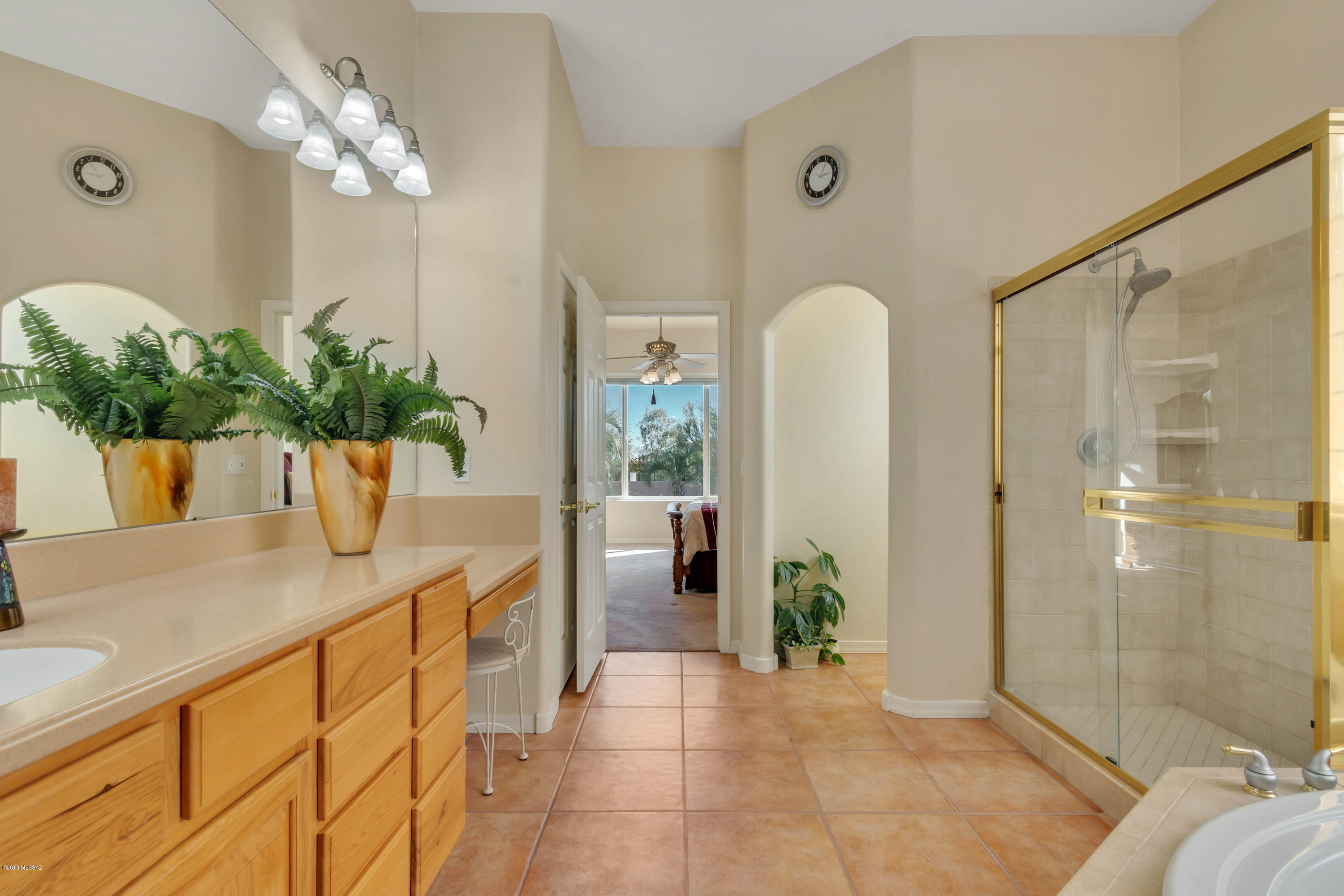 12682 North Spirit Mountain Road Oro Valley, AZ 85755 - Photo 6 of 40 a view of a bathroom with a tub shower and mirror