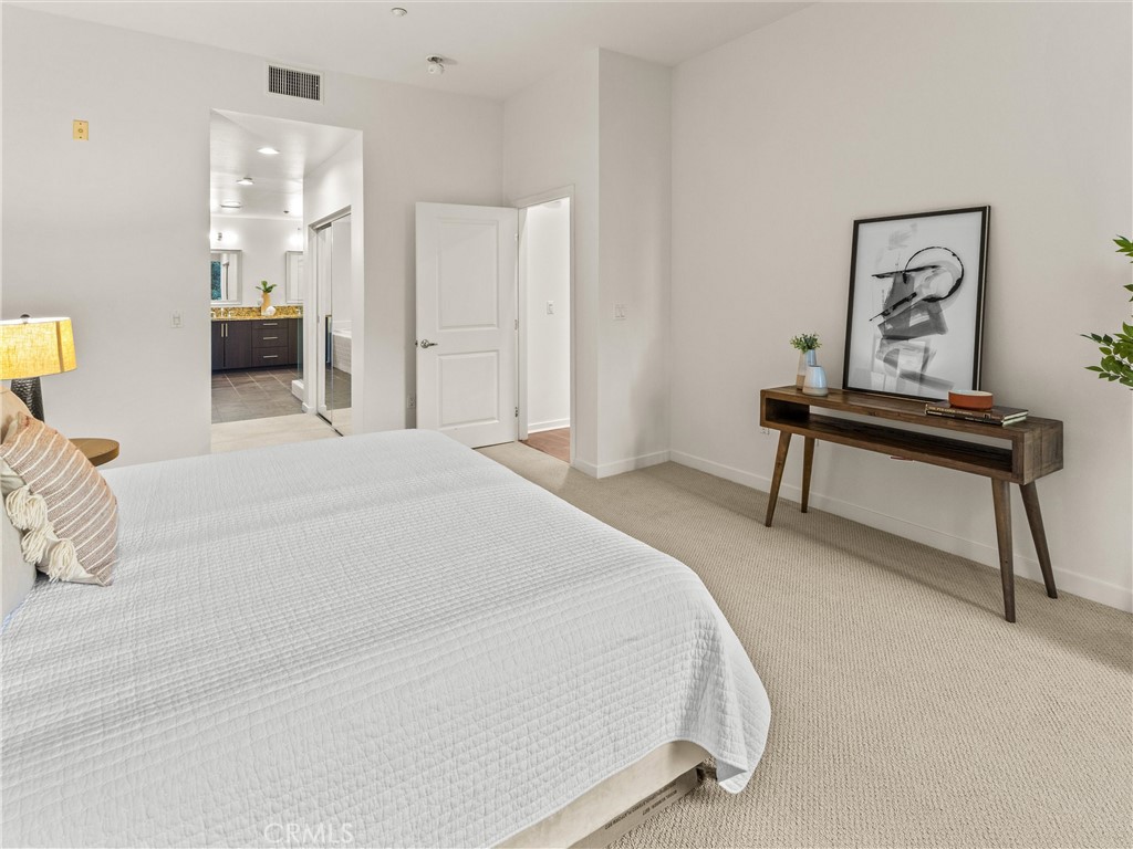 21 Gramercy, Unit 208 Irvine, CA 92612 - Photo 20 of 31 a spacious bedroom with a bed and a table