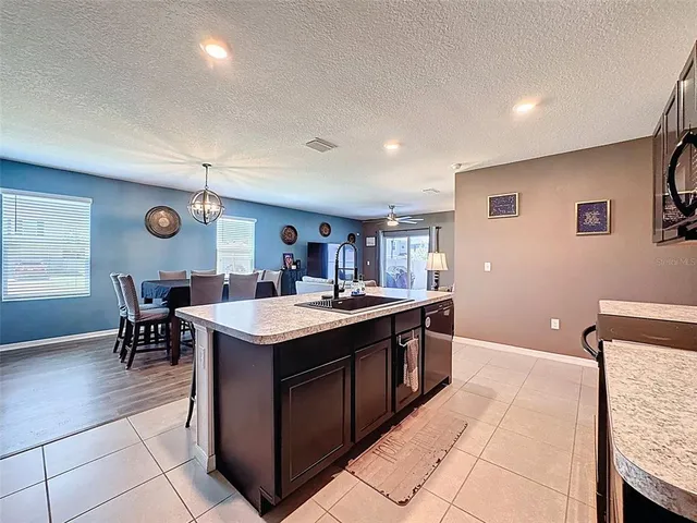 a large kitchen with stainless steel appliances granite countertop a stove refrigerator and cabinets