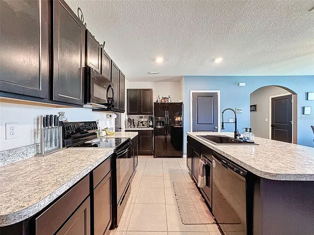 a kitchen with a sink a counter top stainless steel appliances and cabinets