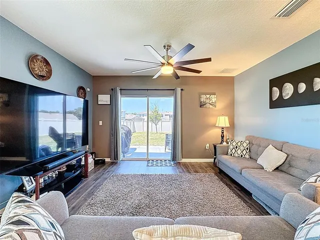 a living room with furniture and a ceiling fan