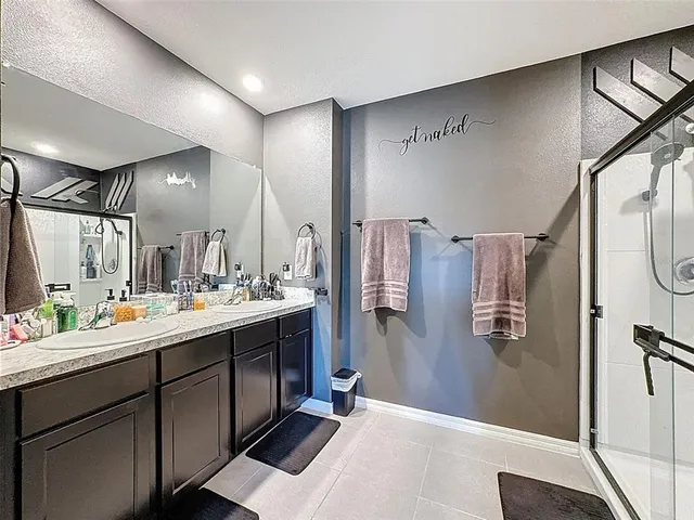 a bathroom with a granite countertop sink a toilet a mirror and shower