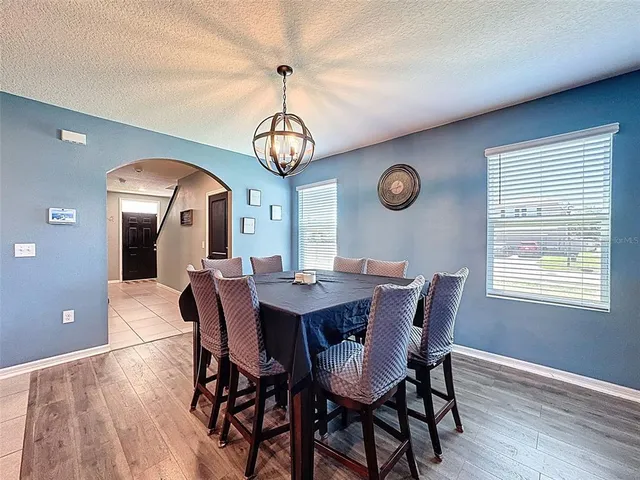 a kitchen with stainless steel appliances kitchen island granite countertop a refrigerator a stove a sink a dining table and chairs