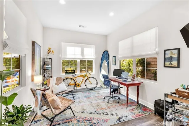 a bedroom with a bed and a flat tv screen next to a window