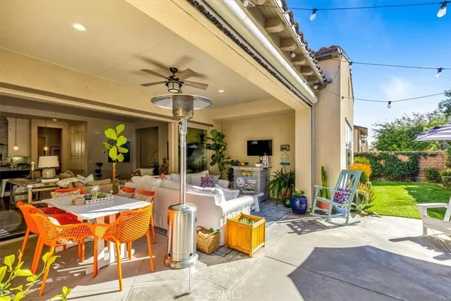 a view of a patio with dining table and chairs under an umbrella with wooden fence
