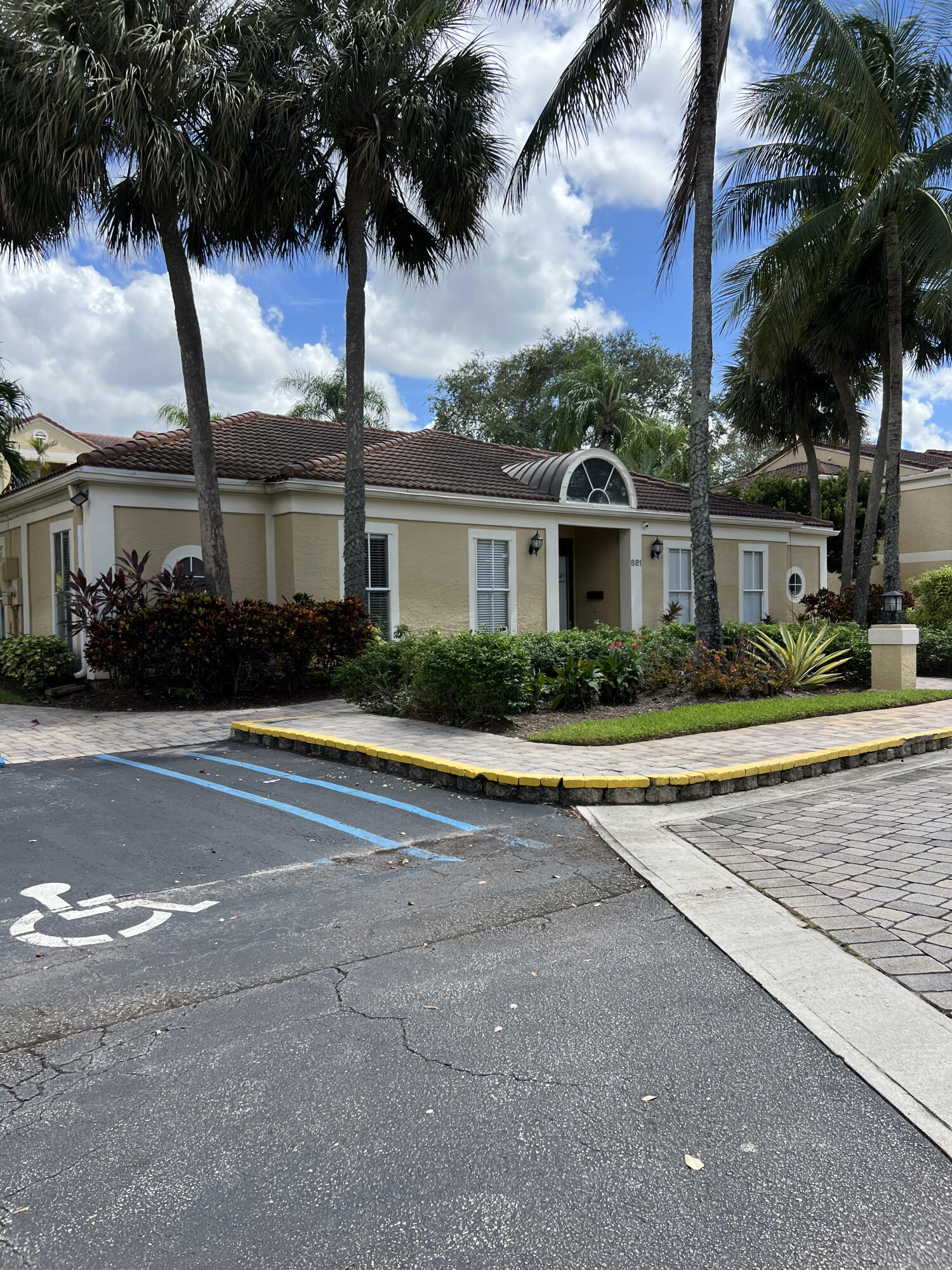 899 Riverside Drive, Unit 620 Coral Springs, FL 33071 - Photo 44 of 46 front view of house with a yard and palm trees