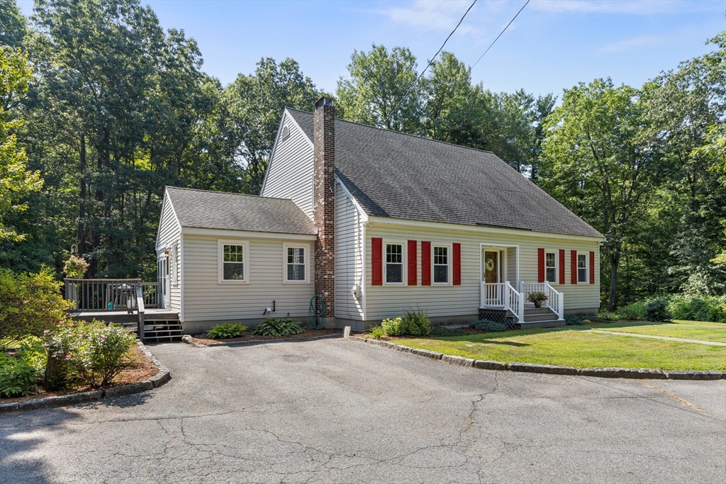 a view of a house with a yard and potted plants