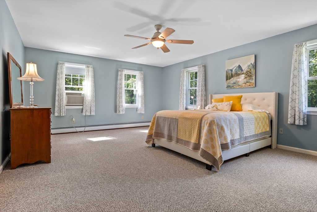 80 Ames Road Groton, MA 01450 - Photo 21 of 40 a bedroom with a bed and a chandelier