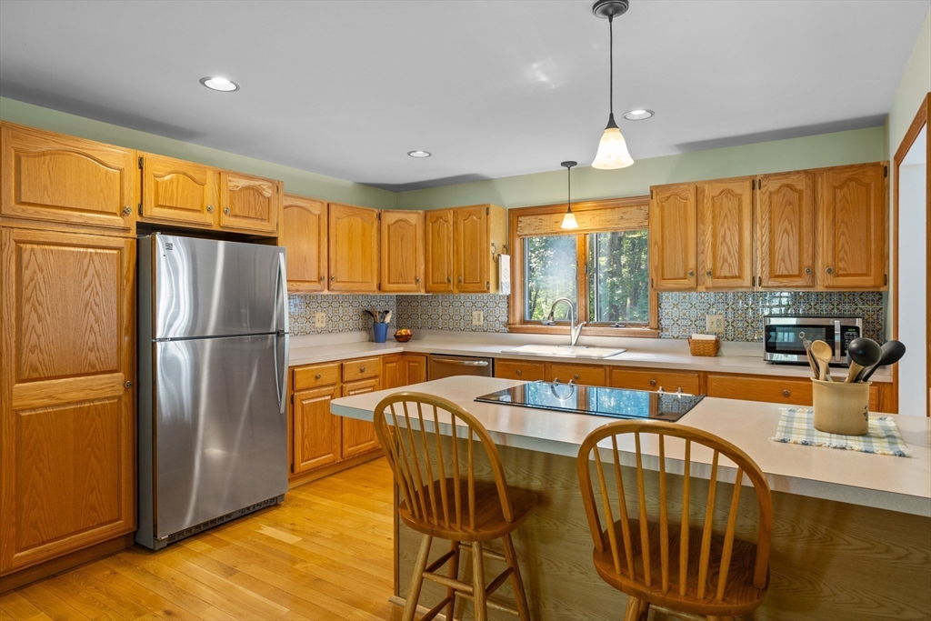 80 Ames Road Groton, MA 01450 - Photo 8 of 40 a kitchen with stainless steel appliances granite countertop a refrigerator a sink a stove a dining table and chairs