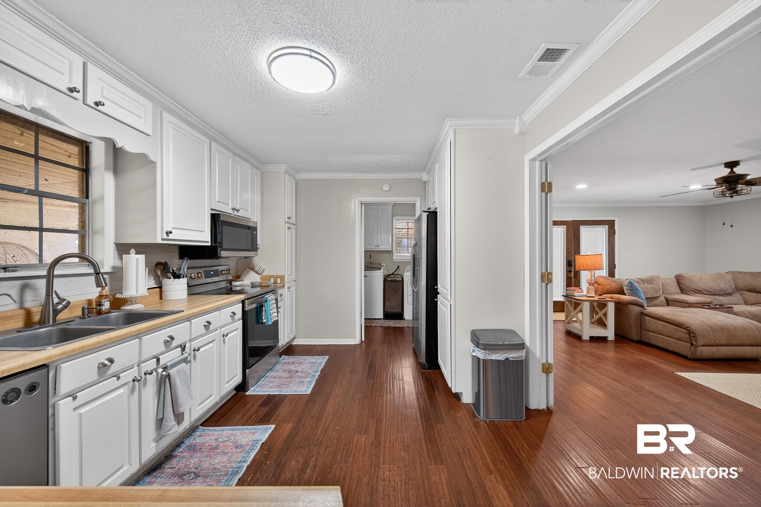 46006 Pecan Lane Bay Minette, AL 36507 - Photo 40 of 40 Kitchen with white cabinets, ornamental molding, ceiling fan, stainless steel appliances, and open floor plan