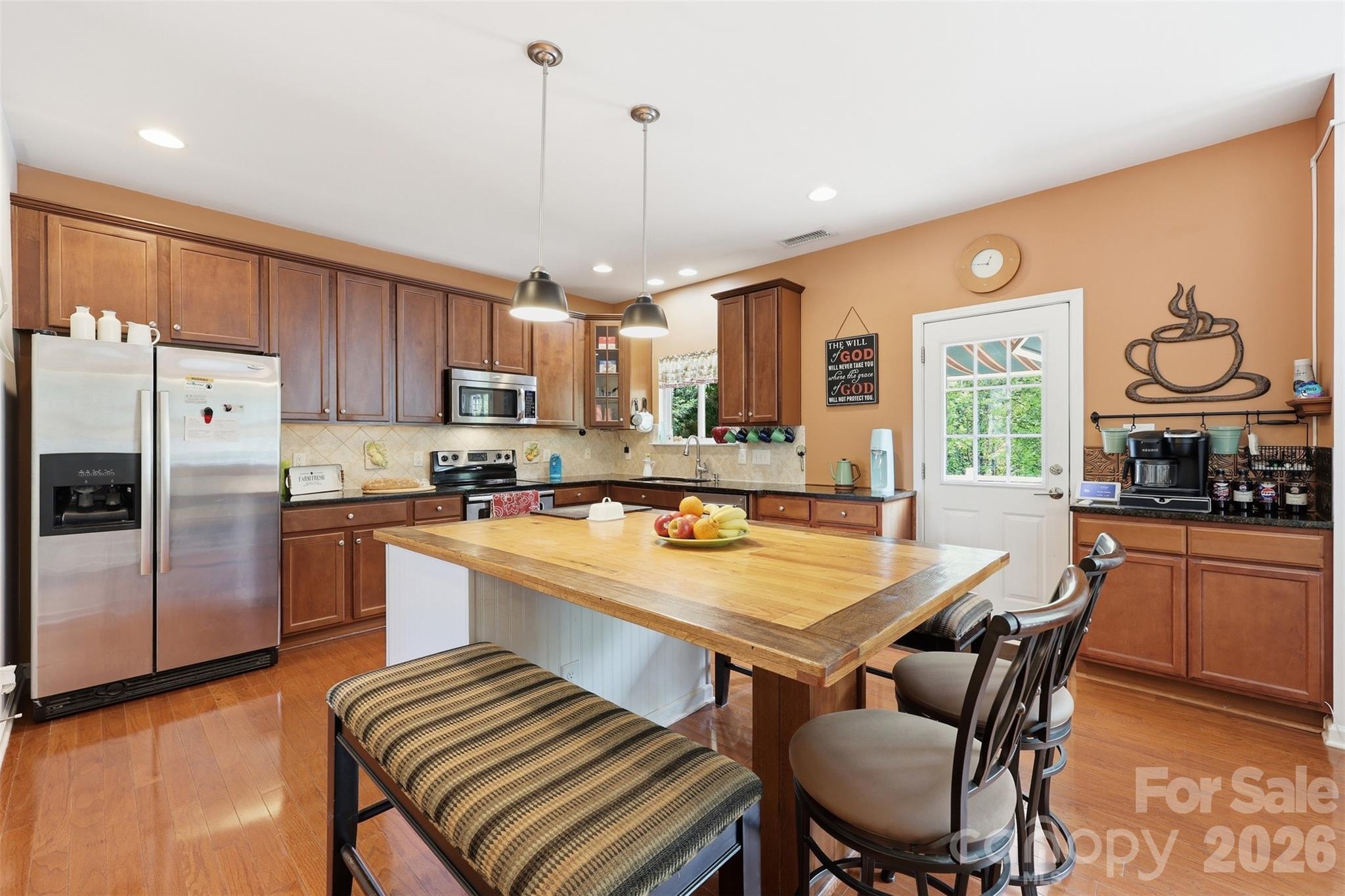 879 Ivy Trail Way Fort Mill, SC 29715 - Photo 5 of 44 a kitchen with granite countertop a table chairs microwave and refrigerator