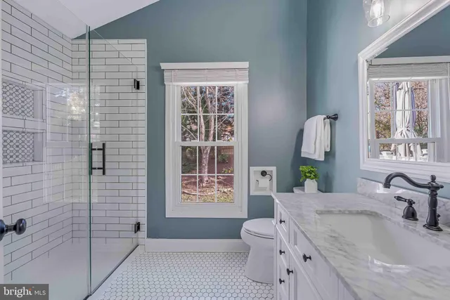 a bedroom with a bed and a table next to a window