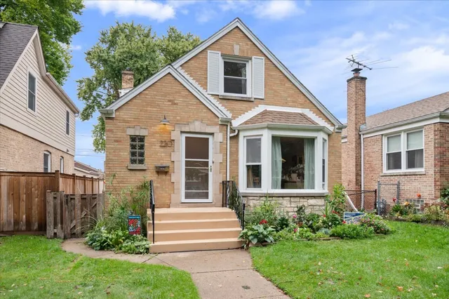 a view of a house with brick walls and a yard with plants