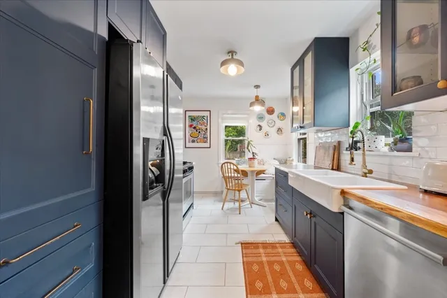 a room with stainless steel appliances kitchen island granite countertop lots of counter top space