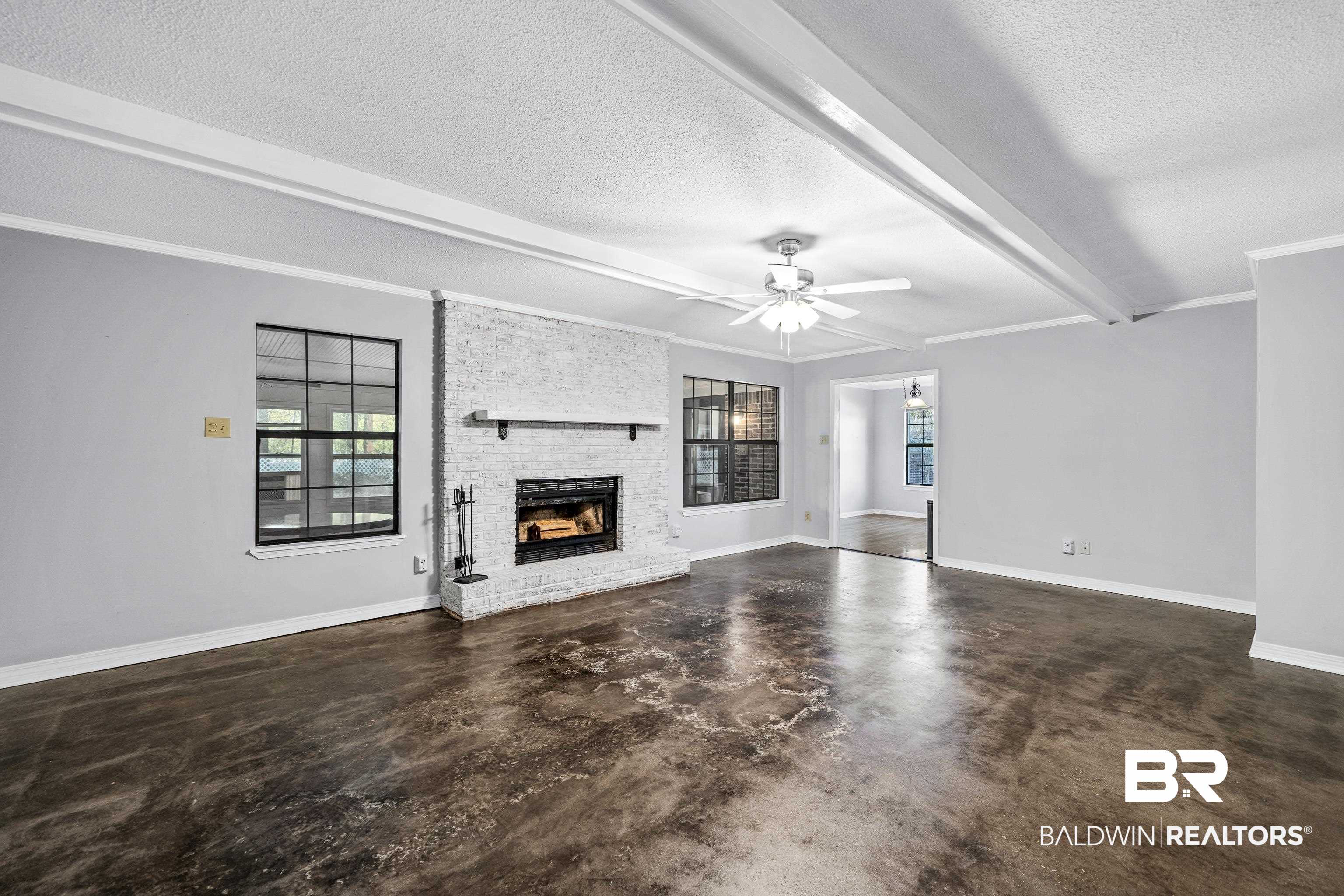 511 Ridgewood Drive Daphne, AL 36526 - Photo 14 of 59 Unfurnished living room with a textured ceiling, beamed ceiling, ceiling fan, ornamental molding, and a brick fireplace