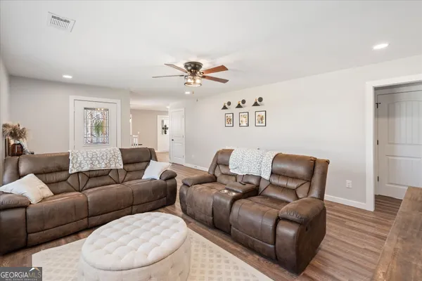 a living room with furniture a ceiling fan and a rug