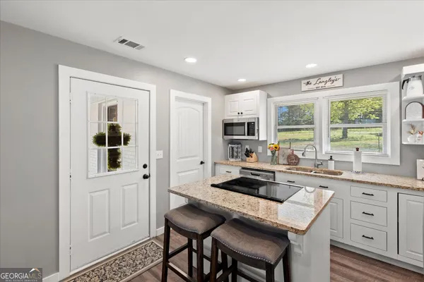 a kitchen with stainless steel appliances granite countertop a stove a sink and a refrigerator with wooden cabinets