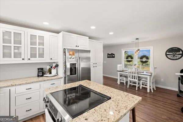a kitchen with stainless steel appliances granite countertop a stove top oven a sink dishwasher and cabinets with wooden floor