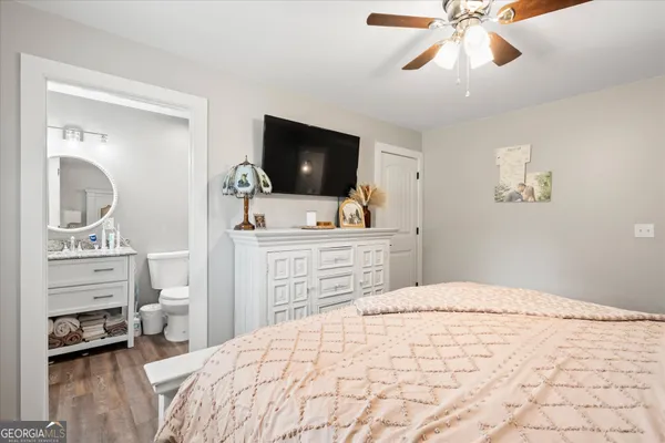 a bedroom with a bed and a flat tv screen on dresser