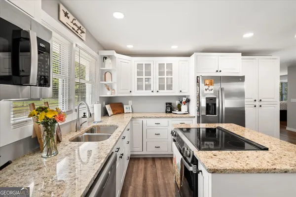 a kitchen that has a lot of cabinets a sink and wooden floor