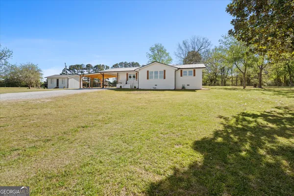 a front view of house with yard and trees in the background