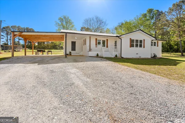 a view of a house with a big yard and large trees