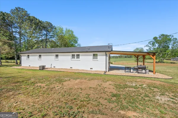 a view of a house with a yard and a large tree