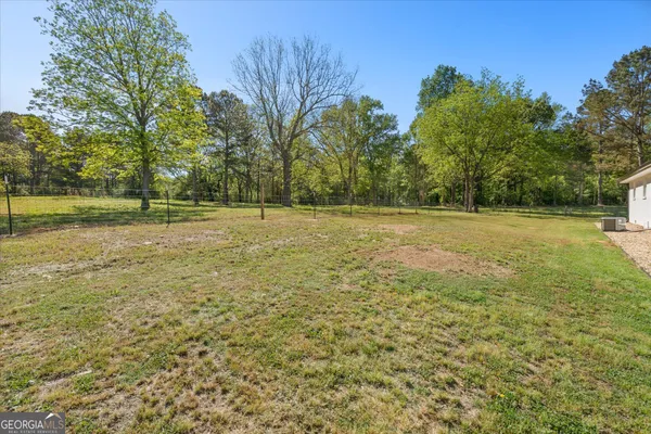 a view of a field with trees in the background