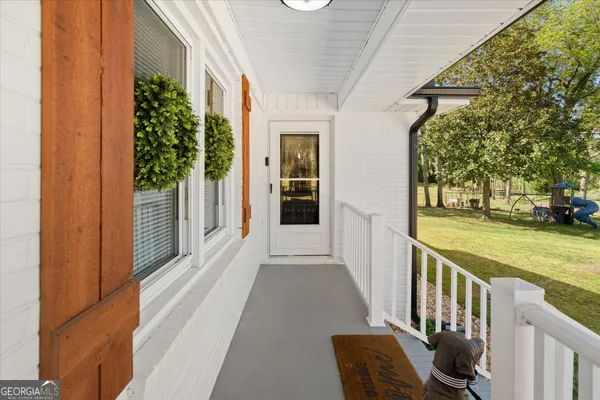 a view of a porch with furniture and garden