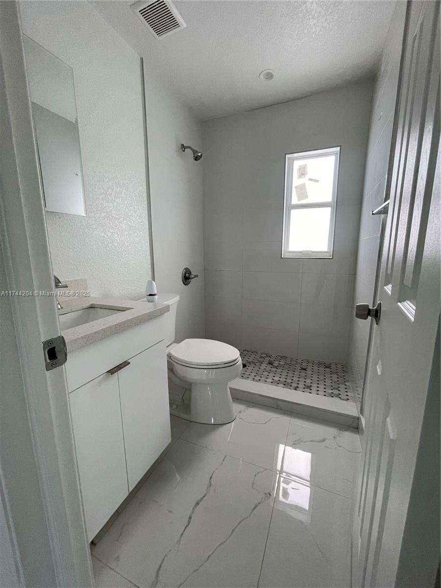 5155 Northwest 12th Avenue Miami, FL 33127 - Photo 13 of 18 a bathroom with a sink a toilet and shower