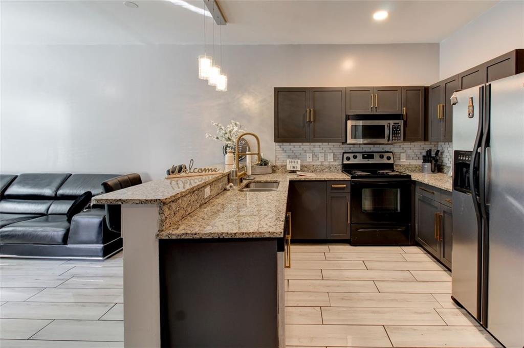 a kitchen with stainless steel appliances granite countertop a sink stove and refrigerator