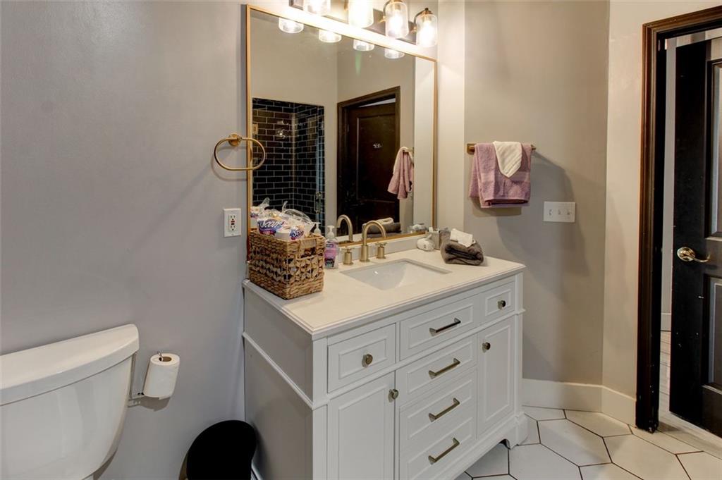 870 Mayson Turner Road Northwest, Unit 1102 Atlanta, GA 30314 - Photo 20 of 27 a bathroom with a sink a toilet and a mirror