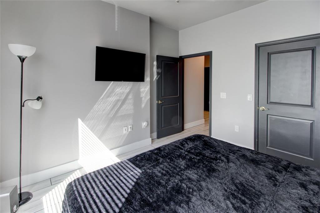 870 Mayson Turner Road Northwest, Unit 1102 Atlanta, GA 30314 - Photo 23 of 27 a living room with a bed and a flat screen tv