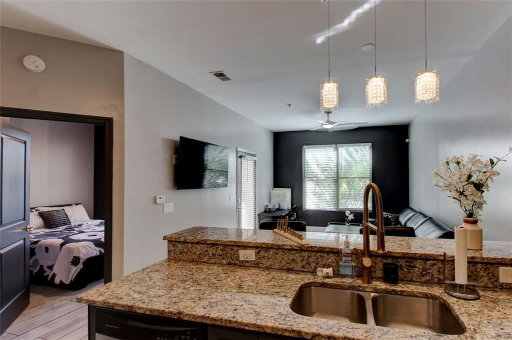 870 Mayson Turner Road Northwest, Unit 1102 Atlanta, GA 30314 - Photo 4 of 27 a kitchen with a sink a counter space and a view of living room