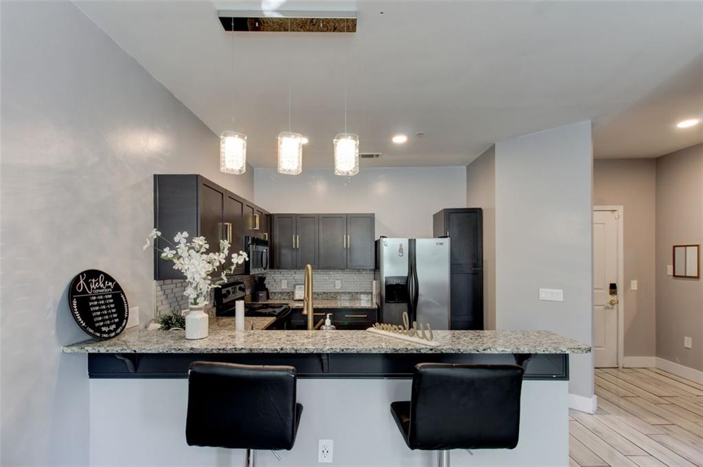870 Mayson Turner Road Northwest, Unit 1102 Atlanta, GA 30314 - Photo 5 of 27 a kitchen with stainless steel appliances a sink and a refrigerator