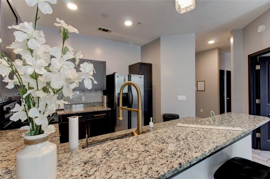 870 Mayson Turner Road Northwest, Unit 1102 Atlanta, GA 30314 - Photo 6 of 27 a bathroom with a granite countertop sink and a large mirror