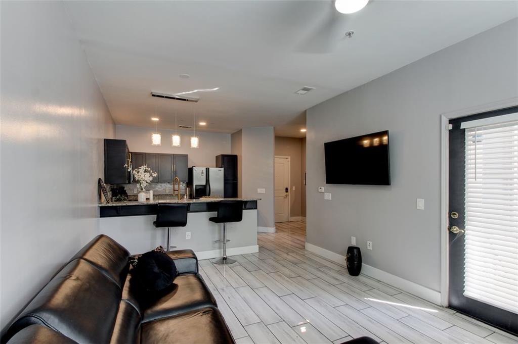 870 Mayson Turner Road Northwest, Unit 1102 Atlanta, GA 30314 - Photo 10 of 27 a view of a livingroom with a flat screen tv wooden floor and a window