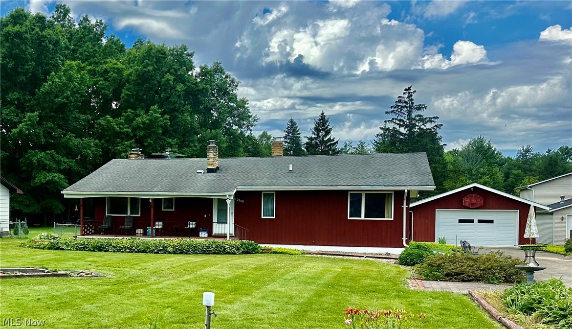View of front of house with an outdoor structure, a garage, and a front yard