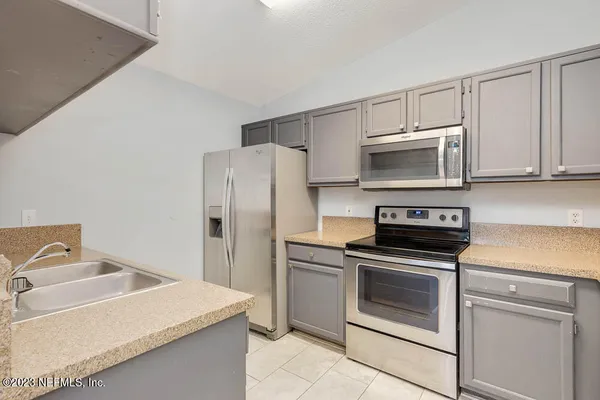 a kitchen with a sink stove and refrigerator