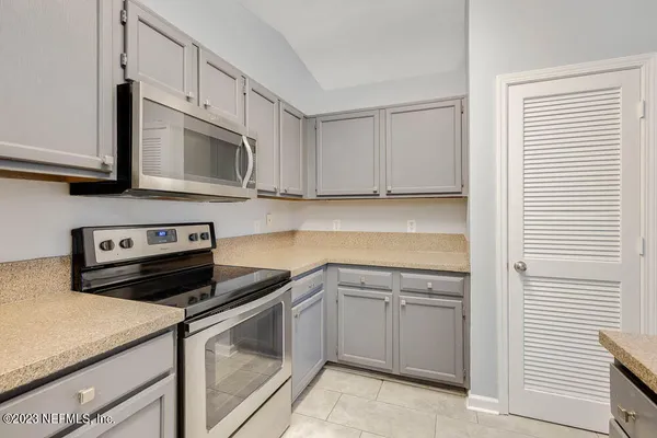 a kitchen with white cabinets and stainless steel appliances